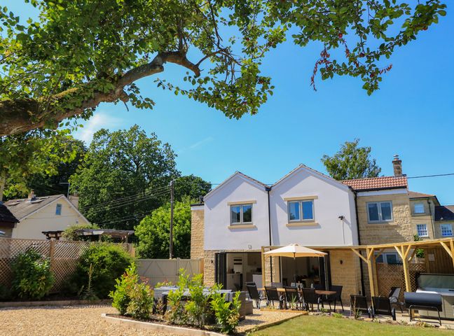 A garden with a house and patio furniture at Cern-Wyn in Chippenham