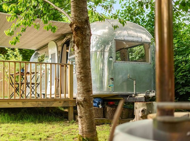A trailer with a deck and table at Sleeps 2 - Private Hot Tub - Fire Pit in St. Dogmaels near Cardigan