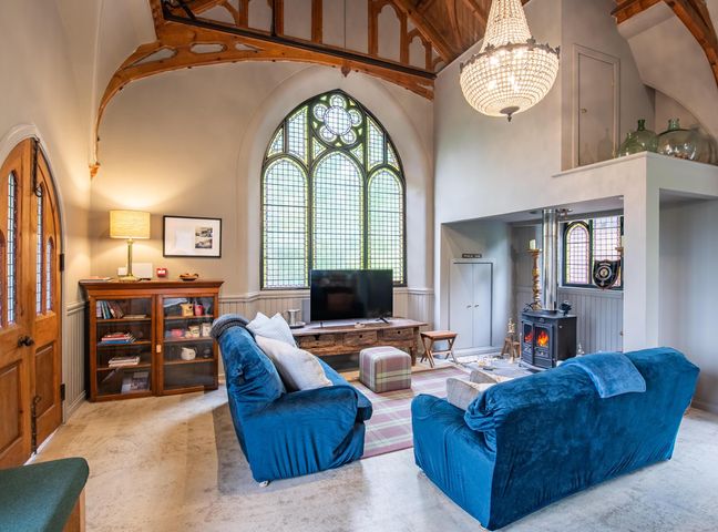 A living room with a sofa and a television at Grade C Church in Cannich