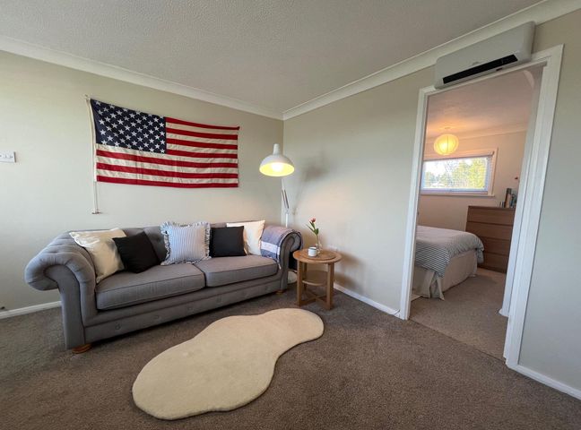 A living room with a flag on the wall and a sofa at The Old Barn in Manchester