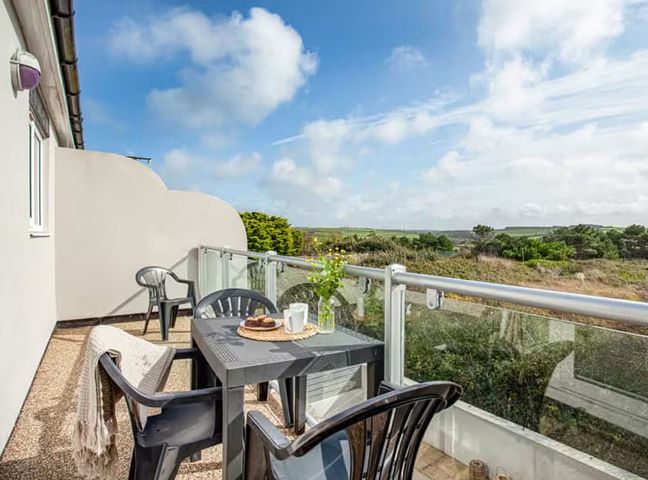 A balcony with a table and chairs at Spacious 3 Bed House Sleeps 6 Parking Wifi in Newquay