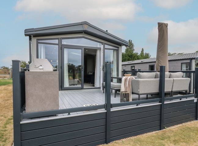 An outdoor area with seating and a grill at Lodge 7 St. Osyth