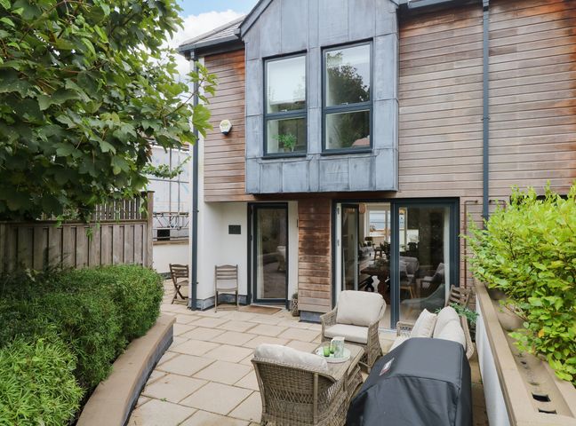 An outdoor patio with seating and grill at Beachstone in Salcombe