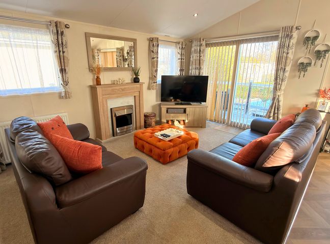 A living room with a television and furniture at Sunset 19 Southview Holiday Park Skegness