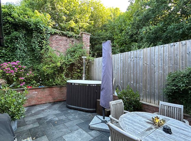 A garden with a hot tub and seating area at Treetops in Southerton near Sidmouth
