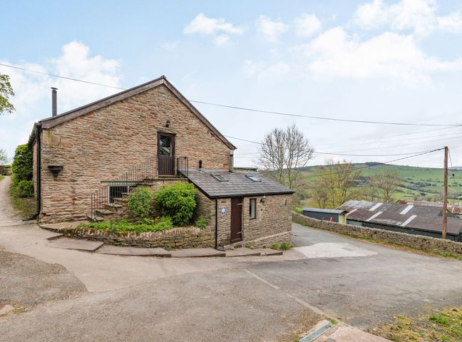 An exterior view of a stone building with stairs and a small garden at The Hayloft in Combs near Buxton