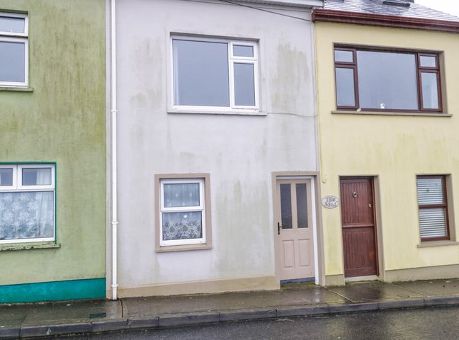 A street view of three adjacent houses with different colored facades and windows at Quayside House Roundstone County Galway