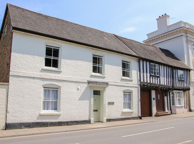 A street view of white and black timber framed historic buildings at The Maltster's House in Ludlow