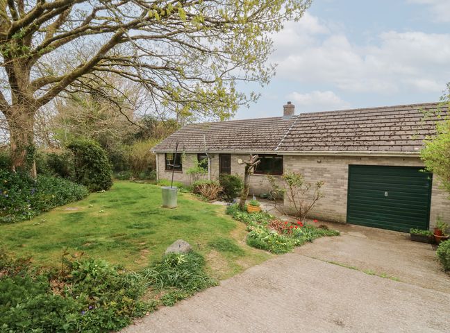 A single story house with a garage and garden with trees and a lawn at Bryn yr Haf in Llanfair Clydogau near Lampeter