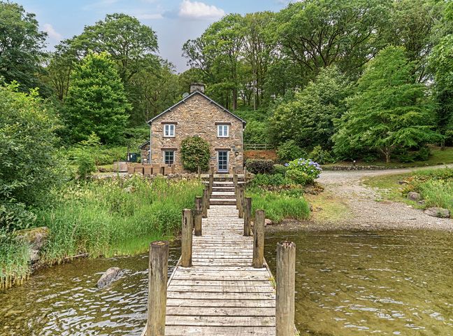 A house by a dock with trees at Hammerhole at the Graythwaite Estate near Hawkshead