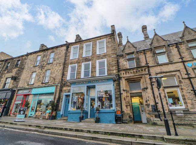 A row of shops on a street including a bespoke tailoring shop and a gelato store at The Flat in Barnard Castle