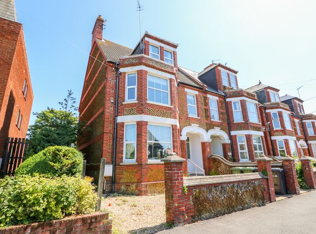 A row of brick terraced houses with bay windows and small front gardens at The Northgate Loft in Hunstanton