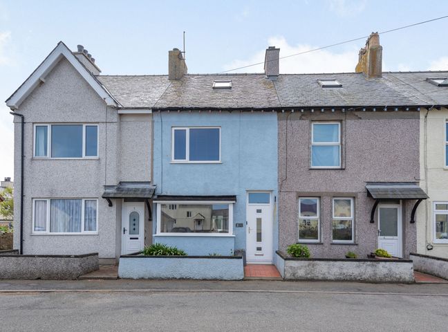 A row of terraced houses with different colored facades and small front gardens at 2 Tregof Terrace in Cemaes Bay