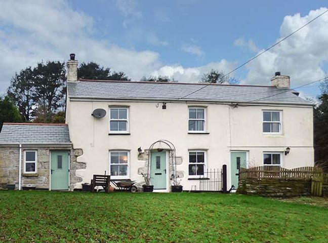 A two story house with three green doors and four windows in a garden at Longview Cottage in Penwithick neat St Austell