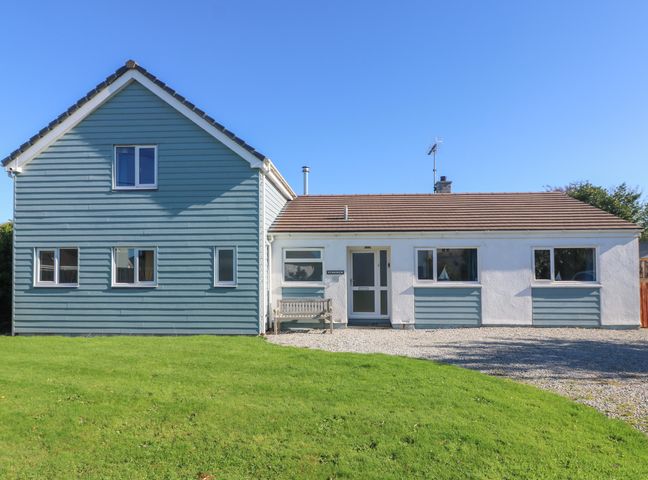 A house with a blue and white exterior and a green lawn at Penhaven in Crackington Haven