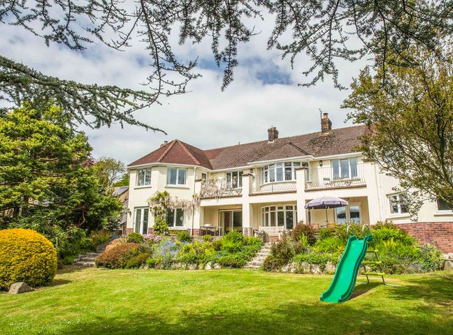 A large house with a garden and green slide in the yard at Nairn in Braunton