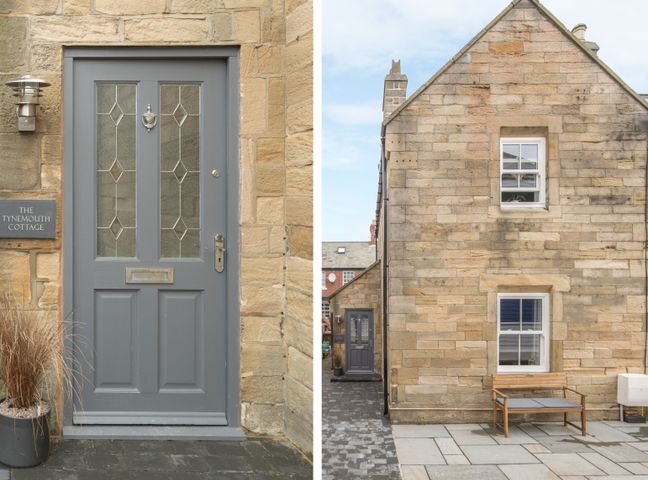 A stone cottage with a grey front door and a wooden bench outside at The Tynemouth Cottage in Tynemouth