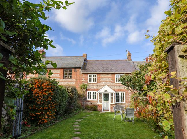 A garden with a house in the background at Poppy Cottage Charlton Marshall