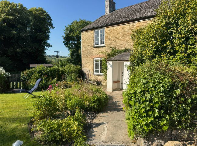 A garden view with a pathway and seating area at Kingbarth in Lerryn