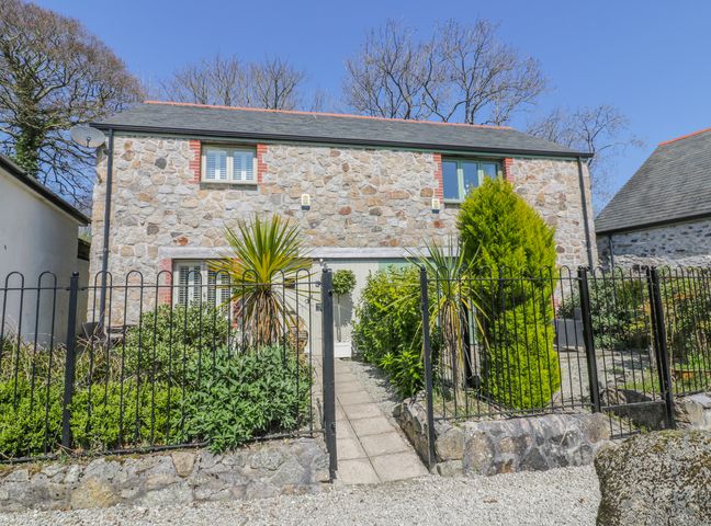 A stone house with a gated front garden and paved pathway at Oh Buoy in Charlestown