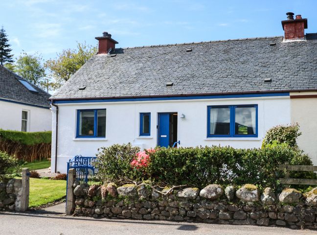A house with a slate roof blue doors windows and a stone wall garden at Marys Cottage in Ardgour