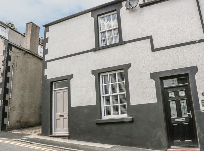 The exterior of a building with two doors and two windows on a street at 22 Uppergate Street in Conwy