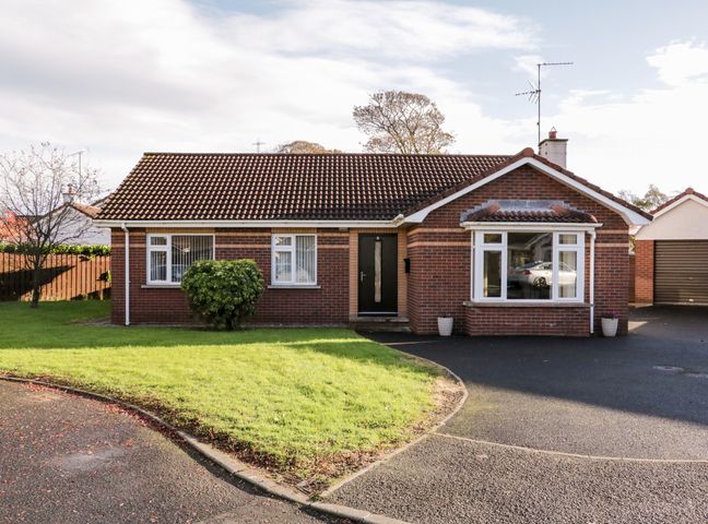 A single story brick house with a tiled roof and front lawn at Coneyville in Culmore Londonderry