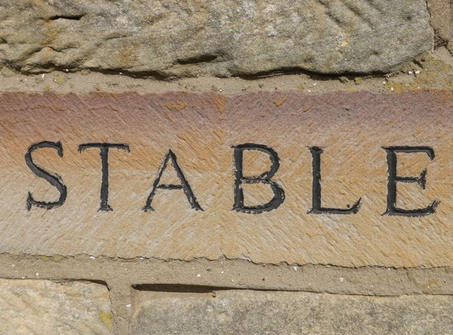 Stone wall with the word stable carved into a stone at Stable Cottage in Staintondale