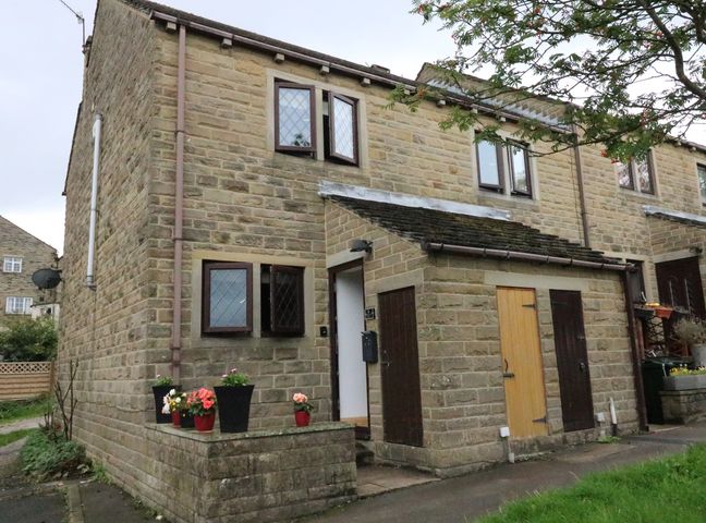 Stone brick two story house with multiple windows potted plants near entrance and wooden doors at Changegate Cottage in Haworth