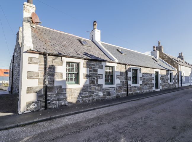 A stone building with a slate roof on a street at 83 Seatown in Cullen