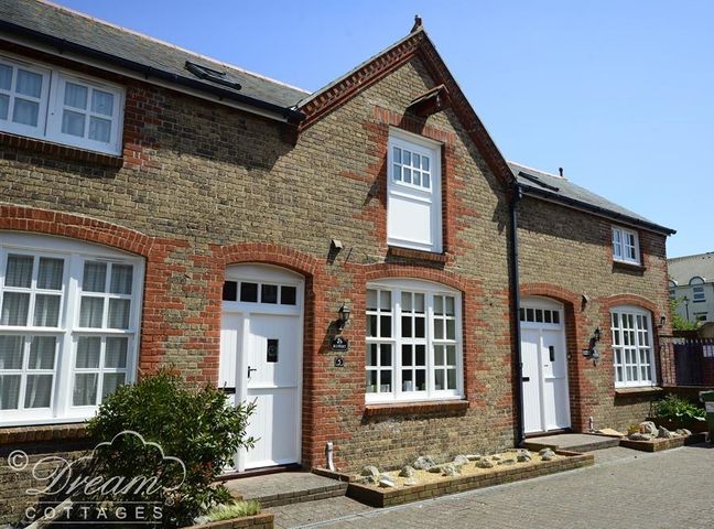 A brick exterior of a cottage with white doors and windows at Rupert Cottage Brewers Quay harbour