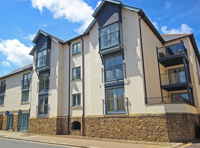 A three-story residential building with balconies and stone base at 5 Dartmouth House in Dartmouth