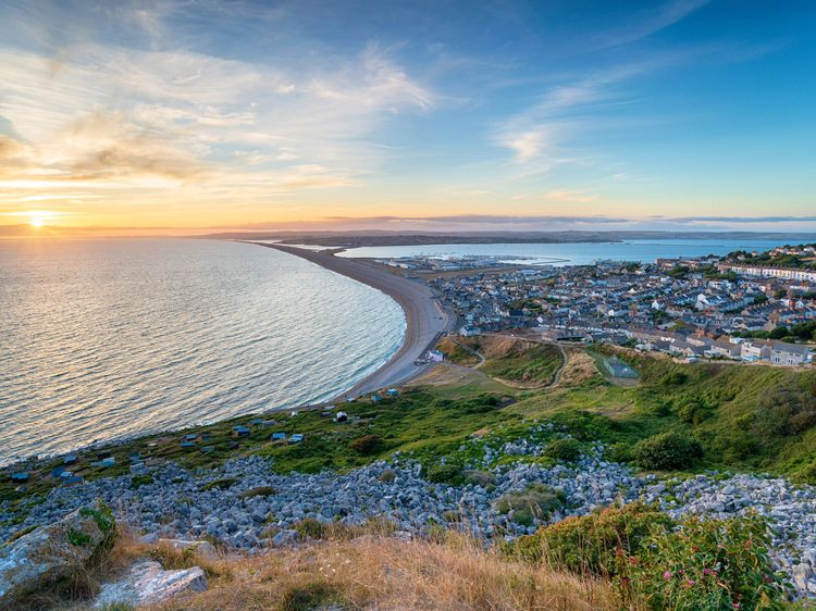 Chesil Beach. 21st August 2018. Two males enjoy swimming off Chesil Beach,  Portland, in Dorset, the