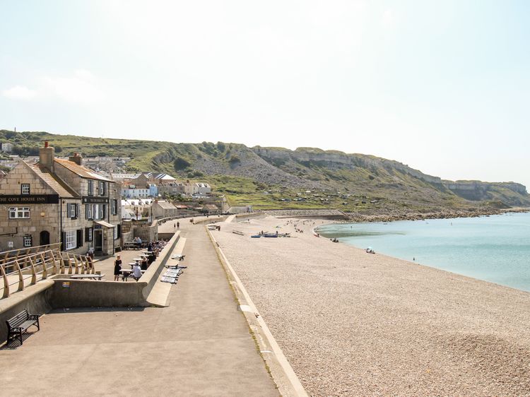 Chesil Beach. 21st August 2018. Two males enjoy swimming off Chesil Beach,  Portland, in Dorset, the