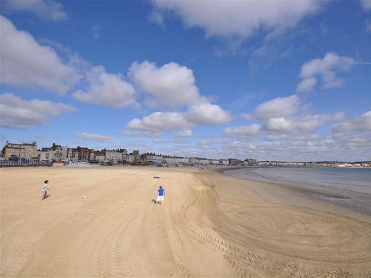 Chesil Beach. 21st August 2018. Two males enjoy swimming off Chesil Beach,  Portland, in Dorset, the