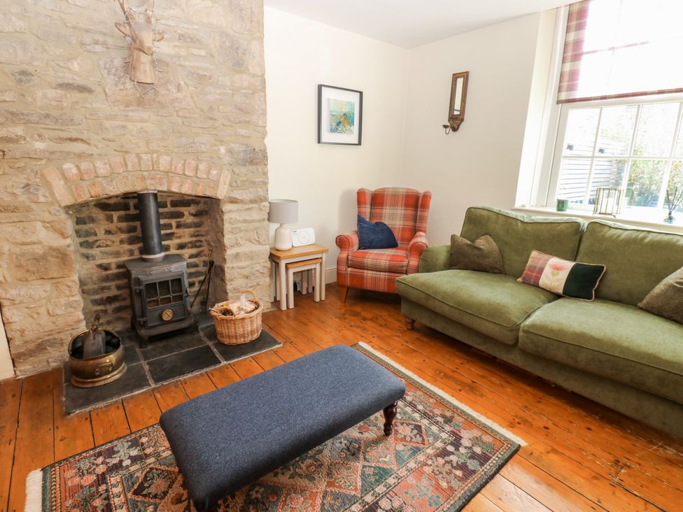 A living room with a fireplace and sofa at Old Workhouse Cottage Stanhope