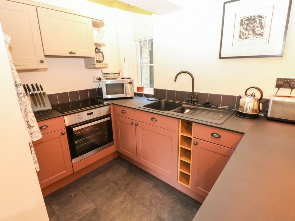 A kitchen with appliances and cabinets at Old Workhouse Cottage in Stanhope