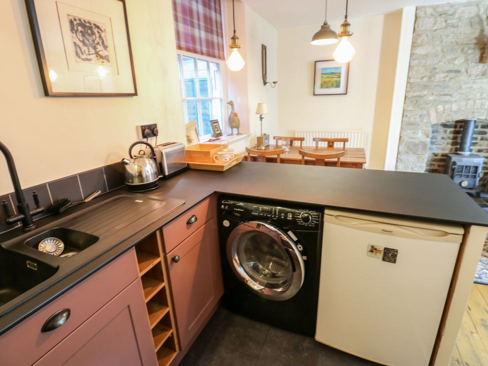 A kitchen with appliances and a dining area at Old Workhouse Cottage in Stanhope