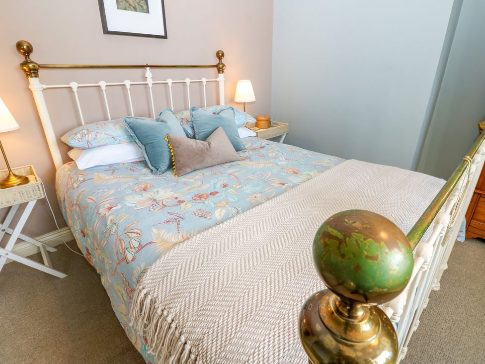 A bedroom with a bed and bedside tables at Old Workhouse Cottage Stanhope