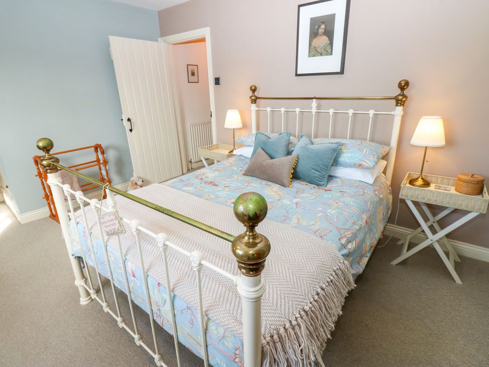 A bedroom with a bed and bedside tables at Old Workhouse Cottage in Stanhope