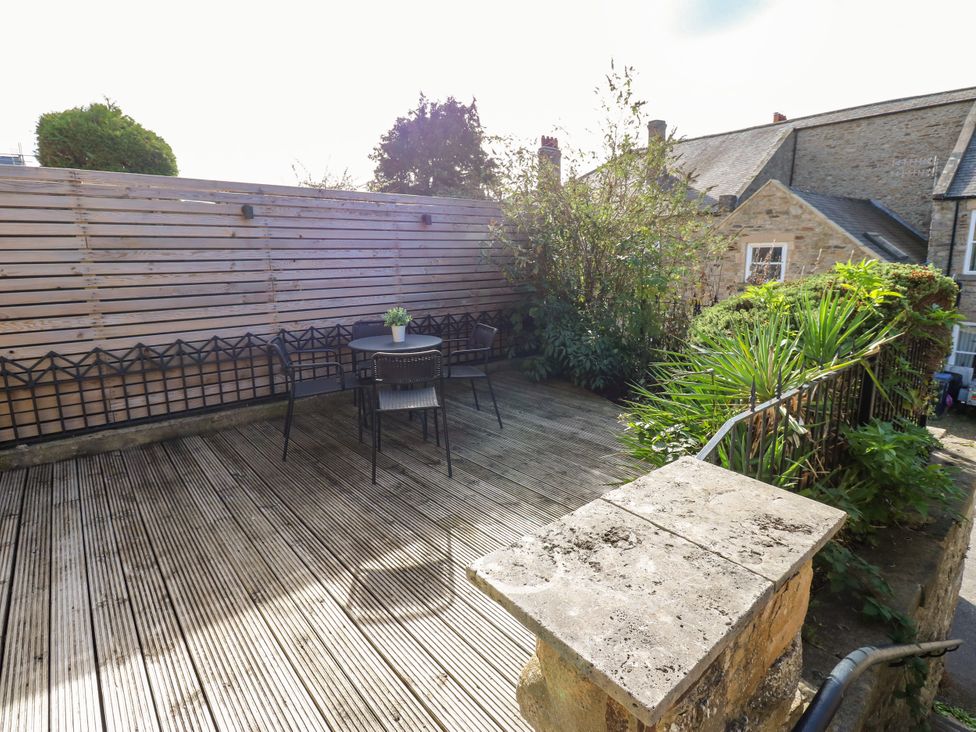 An outdoor area with a table and chairs surrounded by greenery at Old Workhouse Cottage Stanhope
