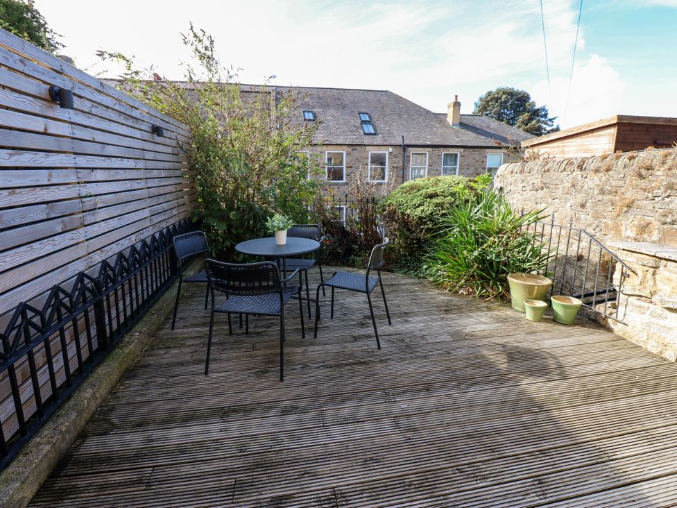A garden area with a table and chairs at Old Workhouse Cottage in Stanhope