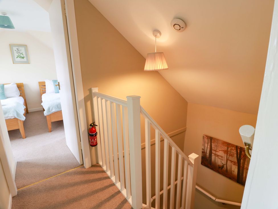A staircase with a fire extinguisher and framed artwork at Cairnhill in Girvan