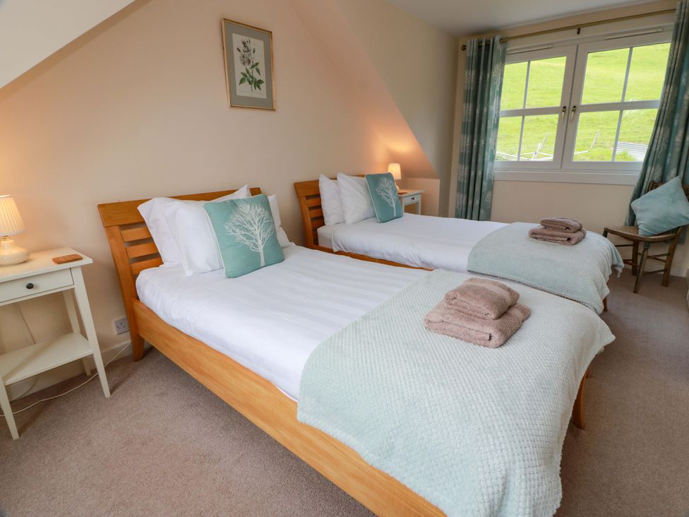 A bedroom with two single beds and a nightstand at Cairnhill in Girvan