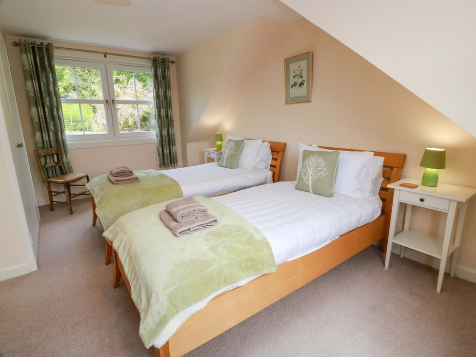 A bedroom with two beds and a nightstand at Cairnhill in Girvan