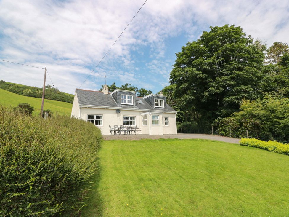 A house with a table and chairs on the lawn at Cairnhill in Girvan