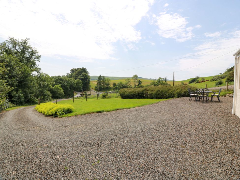 An outdoor area with a gravel driveway and a dining table at Cairnhill in Girvan