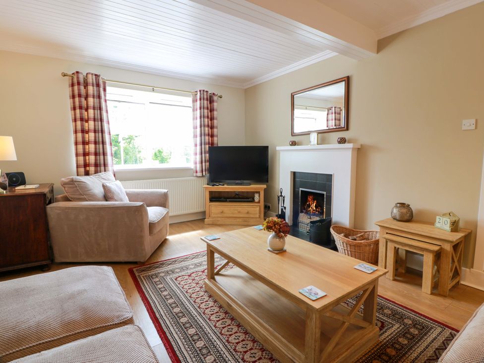 A living room with a sofa, tv, and coffee table at Cairnhill in Girvan