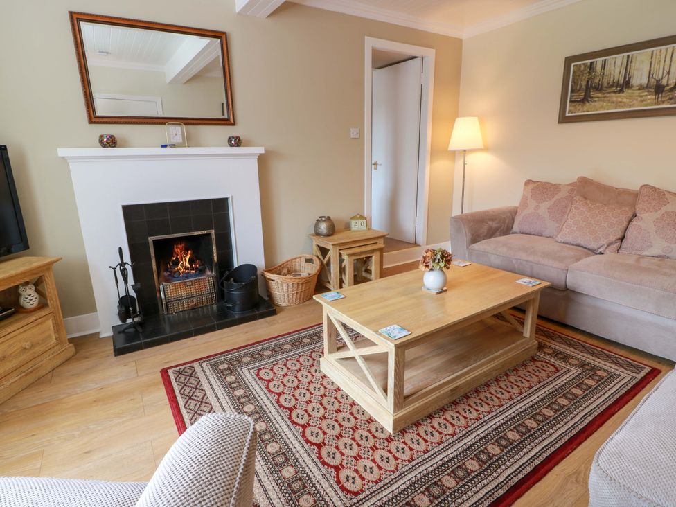 A living room with a fireplace and sofa at Cairnhill in Girvan
