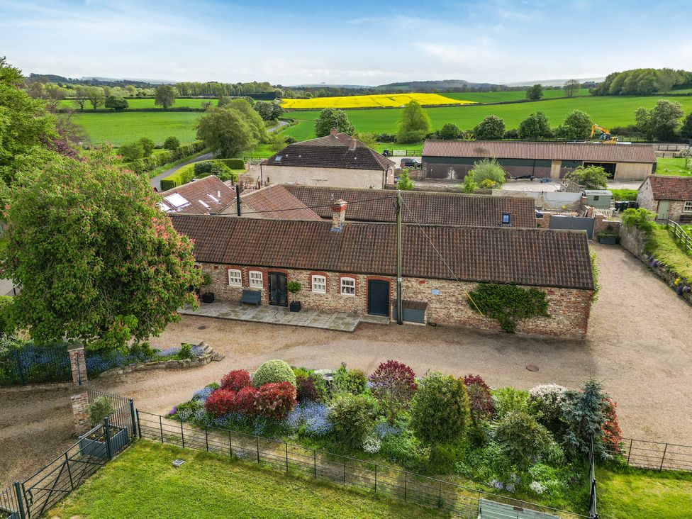 An outdoor view showing buildings and gardens at Sykes Lodge in Malton